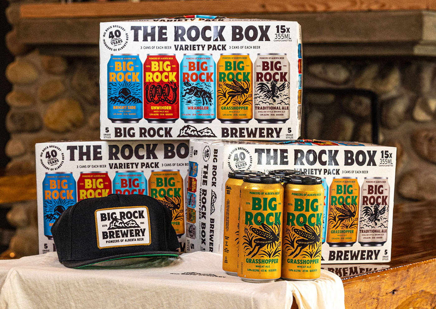 A table with boxes of Big Rock Brewery beer, a four-pack of beer and a Big Rock hat.